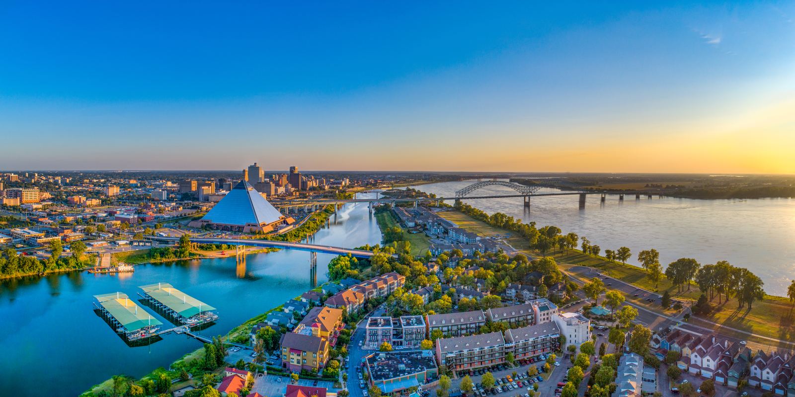 Aerial view of downtown Memphis, the Pyramid, and the Mississippi River at dusk